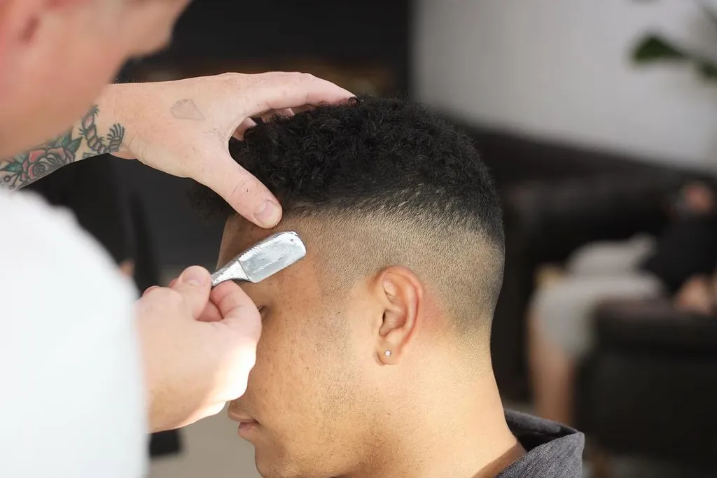 Barber shaping a skin fade with a straight razor at Cry Baby Barber Shop