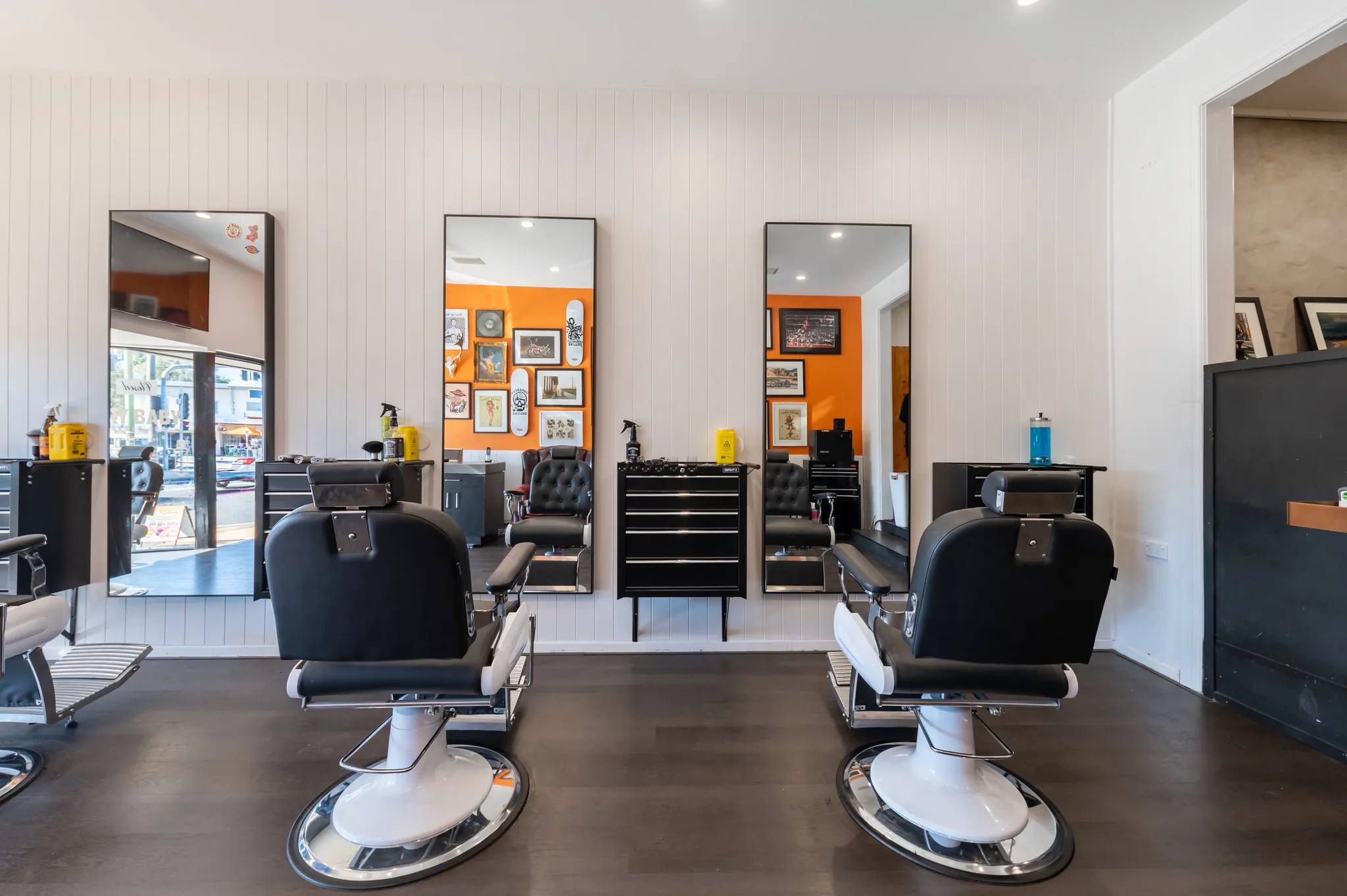 Two barber chairs facing the mirrors inside Cry Baby Barber Shop